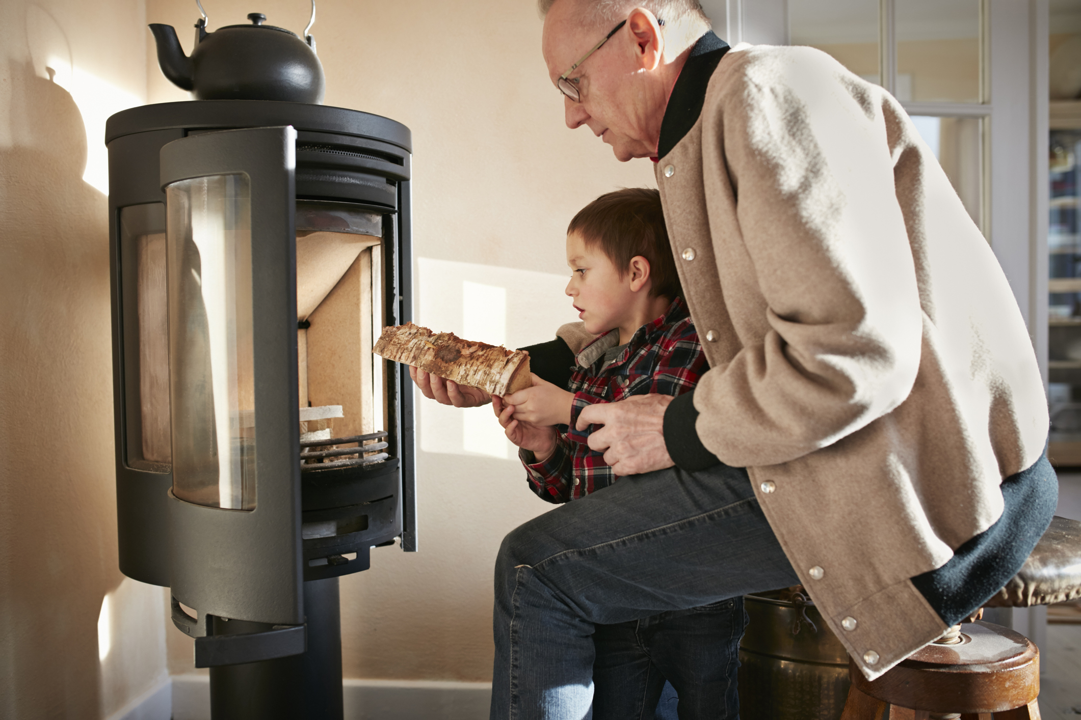 Grandfather & grandson building a fire