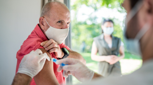 Senior man with face mask getting vaccinated, coronavirus concept.