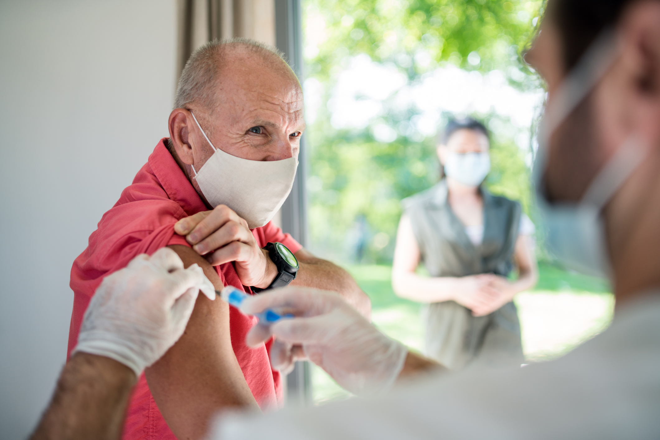 Senior man with face mask getting vaccinated, coronavirus concept.