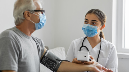 Healthcare worker attends to a senior man in a home