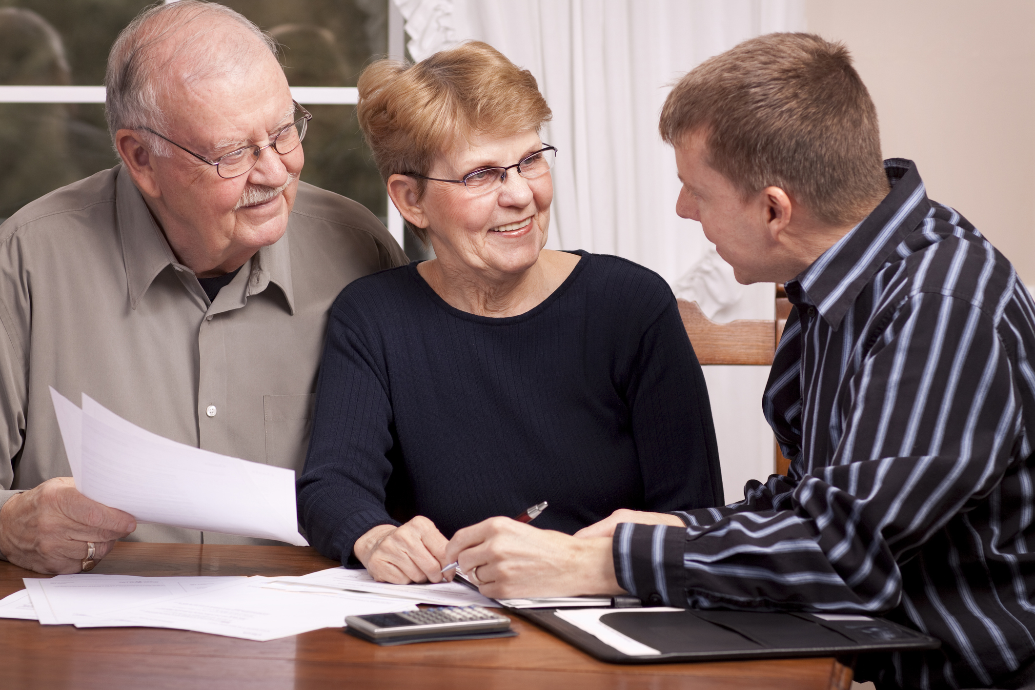 Man giving financial advisor to senior couple smiling