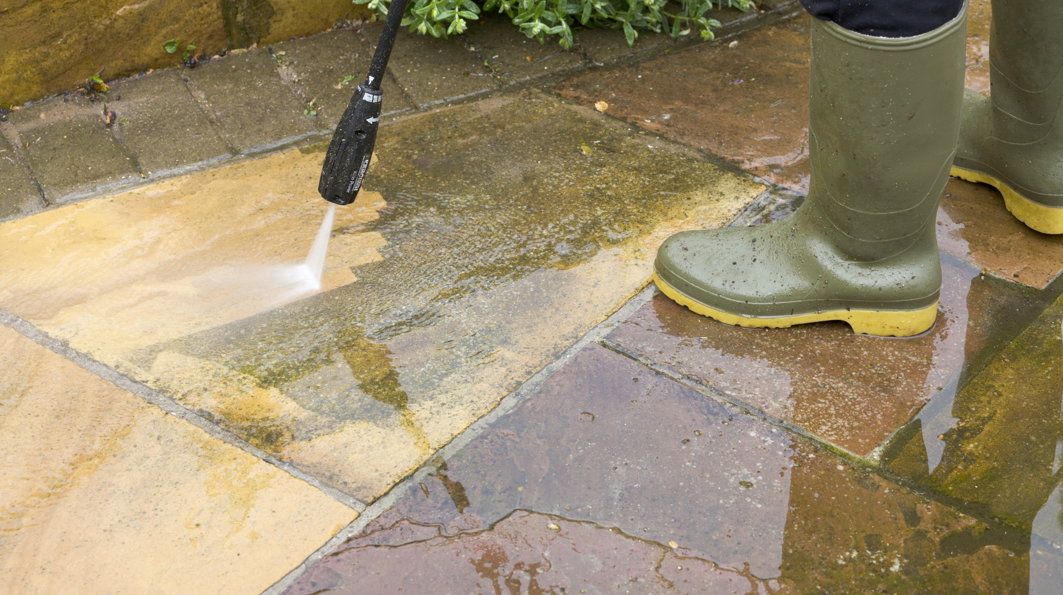 Man jet washing patio