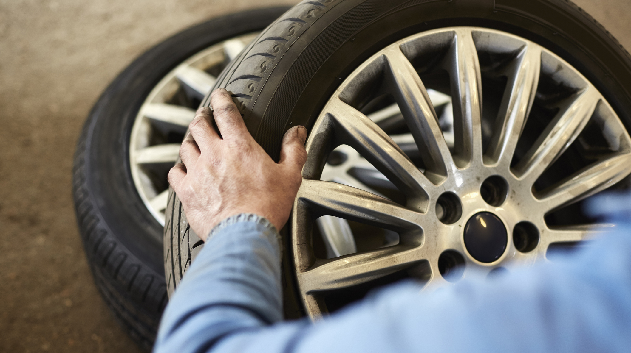 Garage mechanic examining car tyre