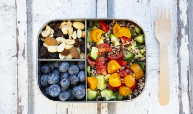 Lunchbox with quinoa salad with tomato and cucumber, blue berry and trail mix