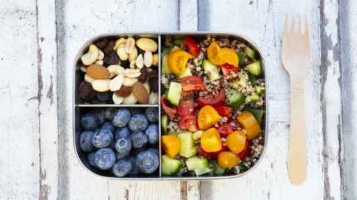 Lunchbox with quinoa salad with tomato and cucumber, blue berry and trail mix
