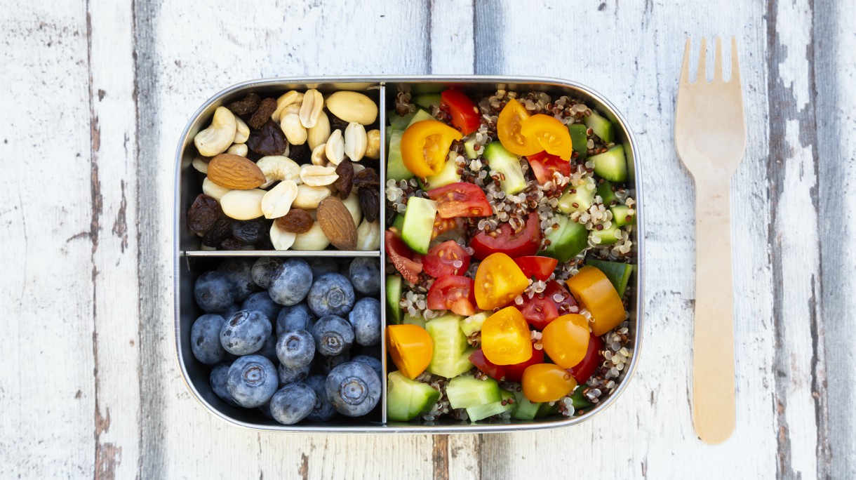 Lunchbox with quinoa salad with tomato and cucumber, blue berry and trail mix