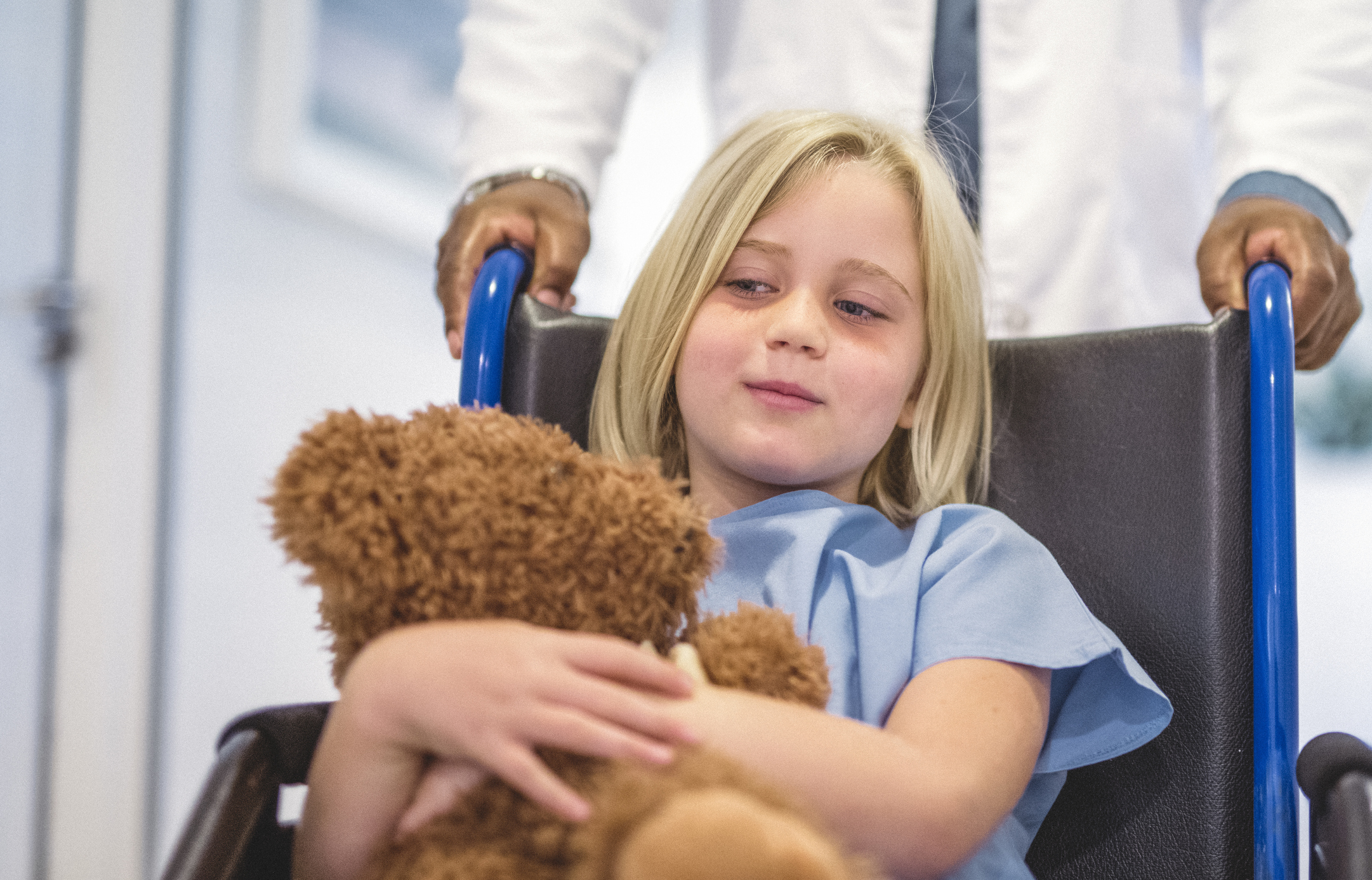 Midsection of doctor pushing girl on wheelchair