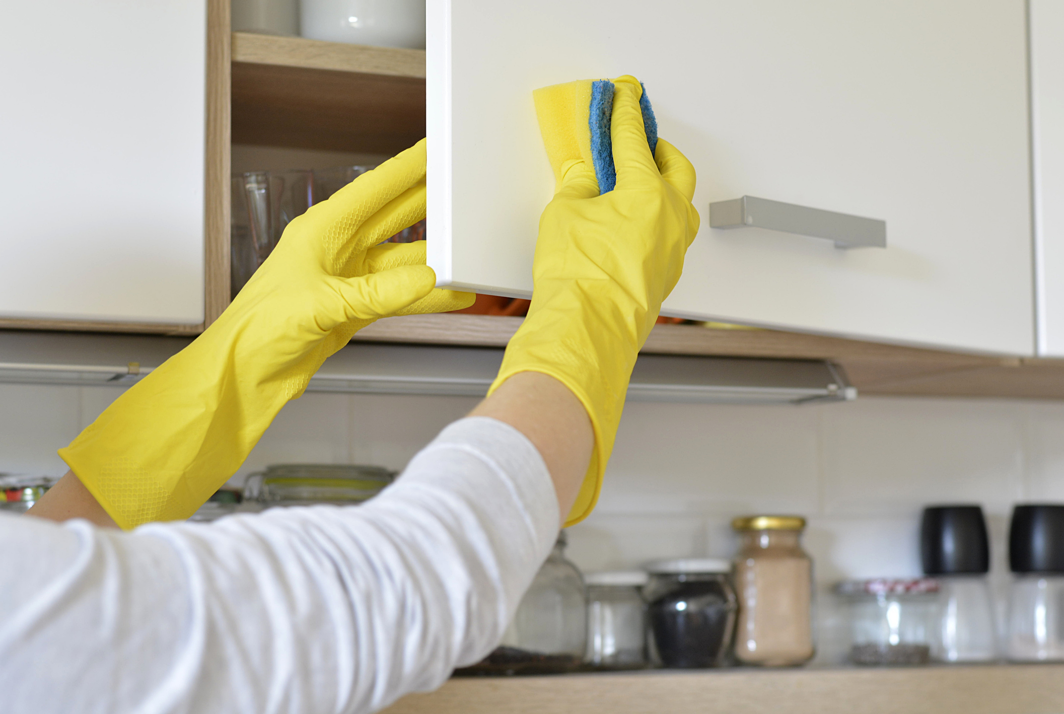 Cropped Hands Of Person Cleaning Cabinet Door At Home