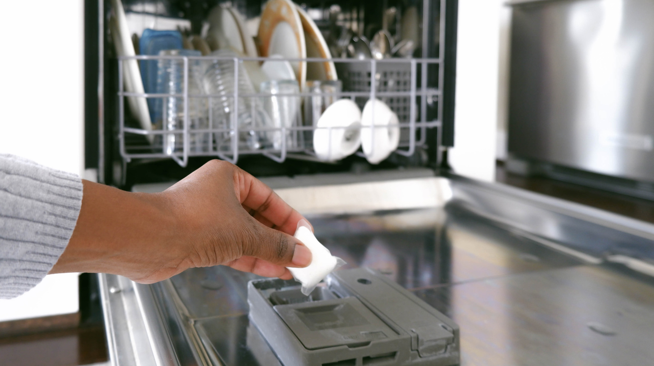 Woman Puts Dishwasher Detergent Into Dispenser
