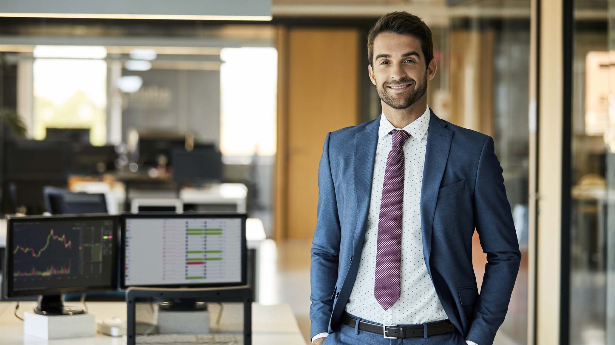 Happy Businessman With Hands In Pockets At Office