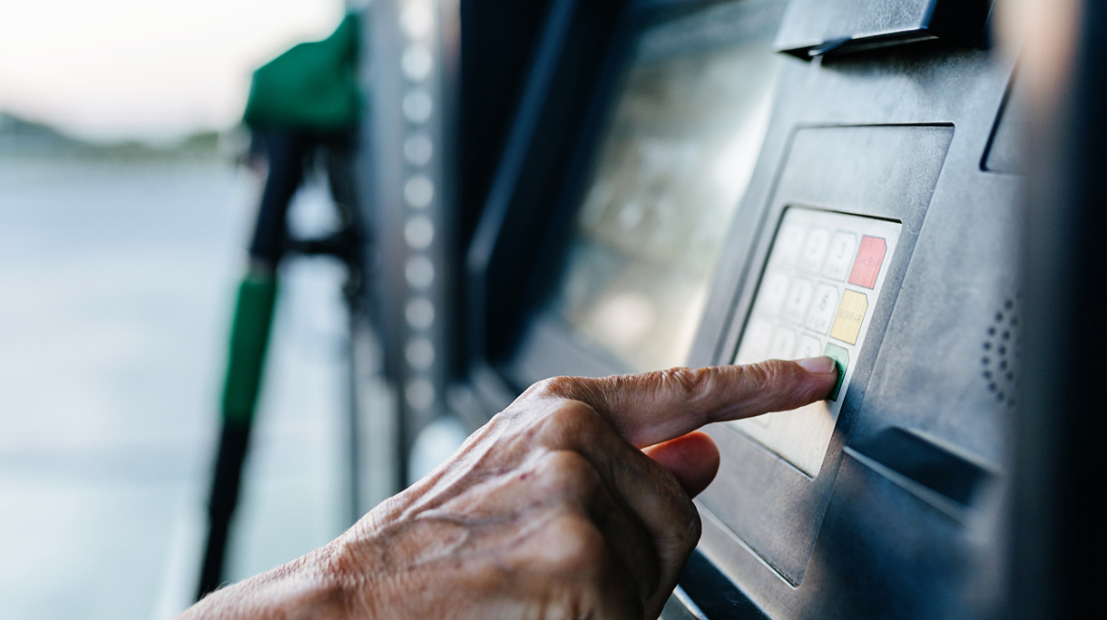 Senior woman paying for the fuel with a credit card at the gas sta