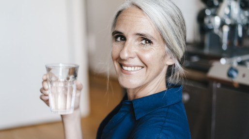 Portrait of smiling businesswoman holding glass of water