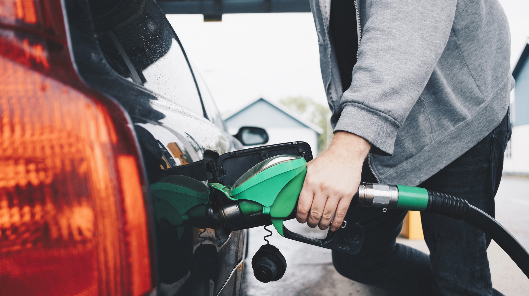 Midsection of man refueling car at gas station