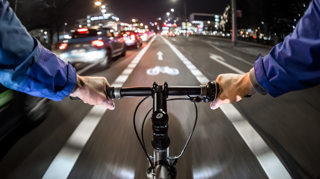 Cyclist drives on the bike path past the traffic jam