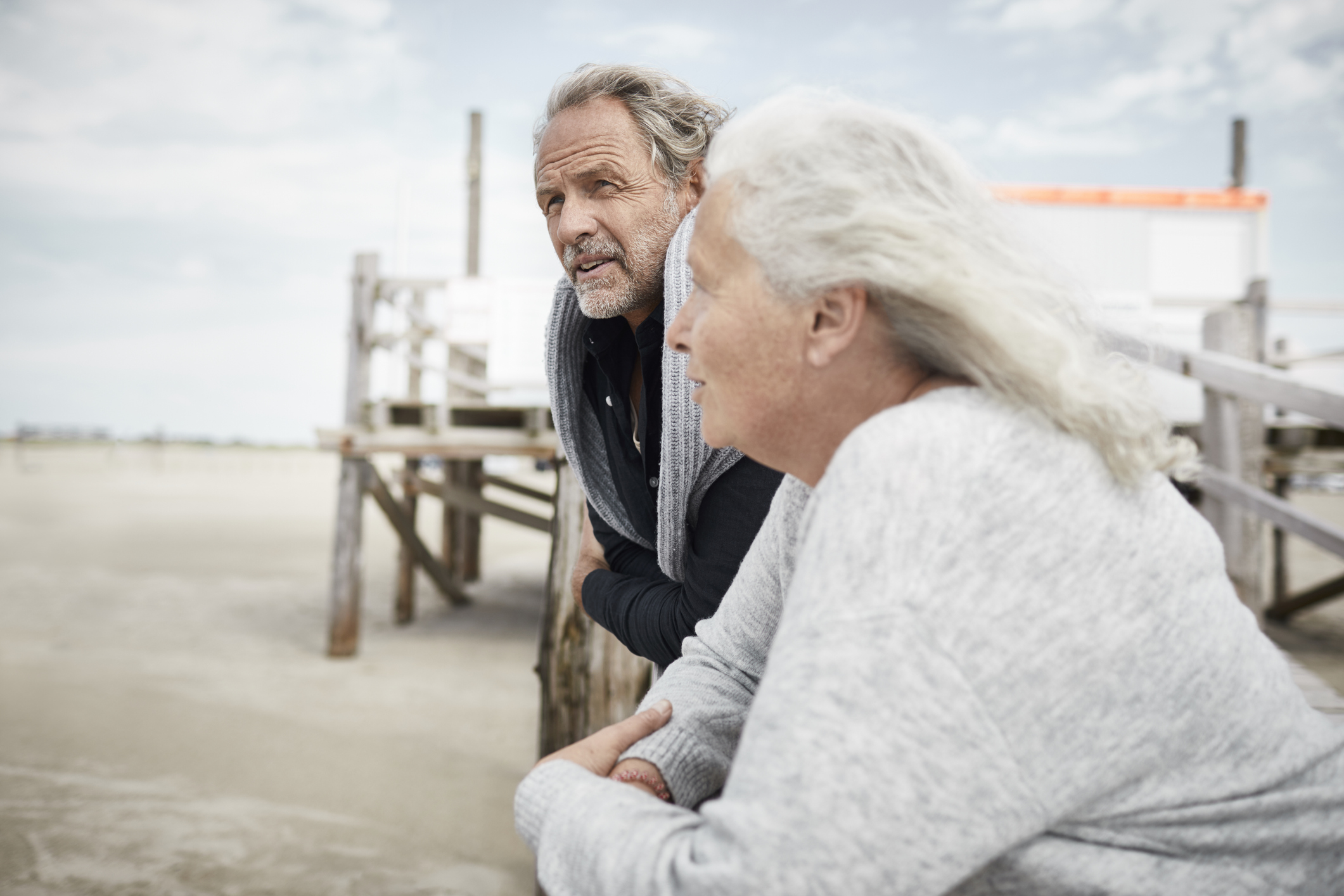 Senior couple standing on boardwalk on the beach