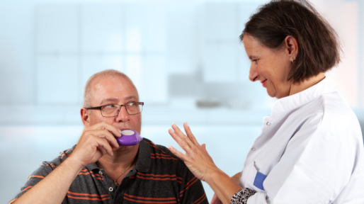 nurse explains an inhaler to a patiënt