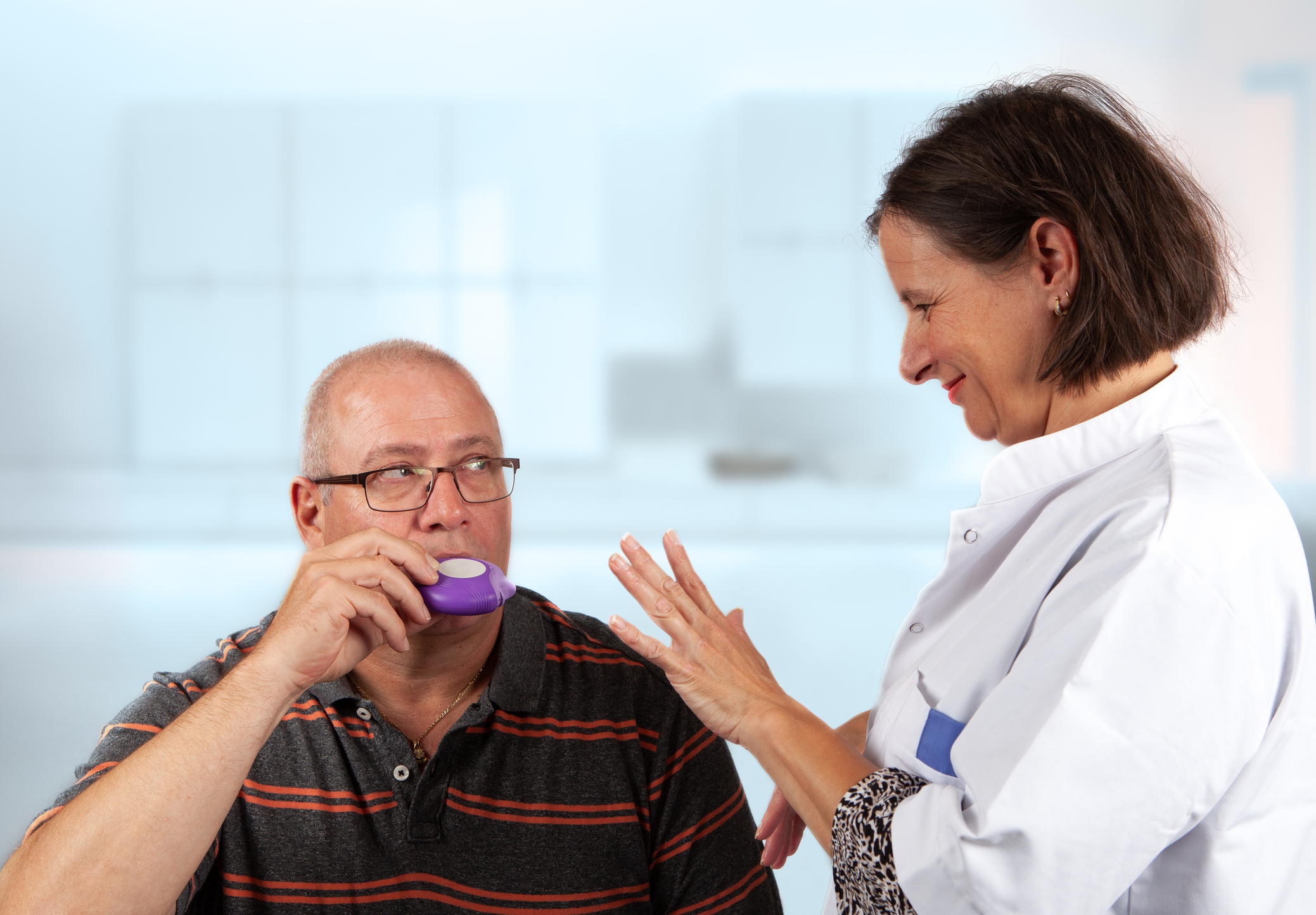 nurse explains an inhaler to a patiënt