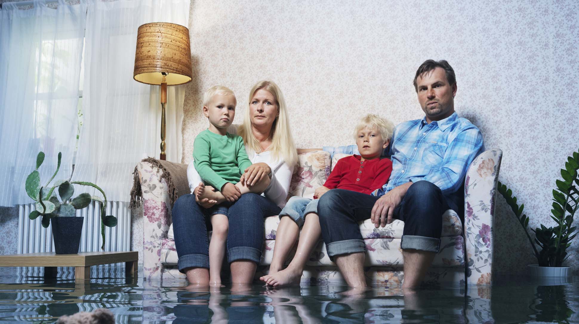 family in sofa in flooded room