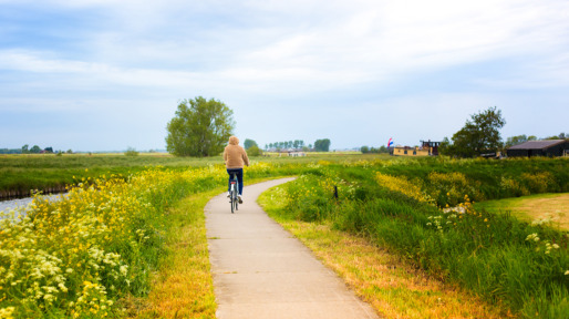 Young Woman Cyclist near Canal, Springtime (Netherlands)