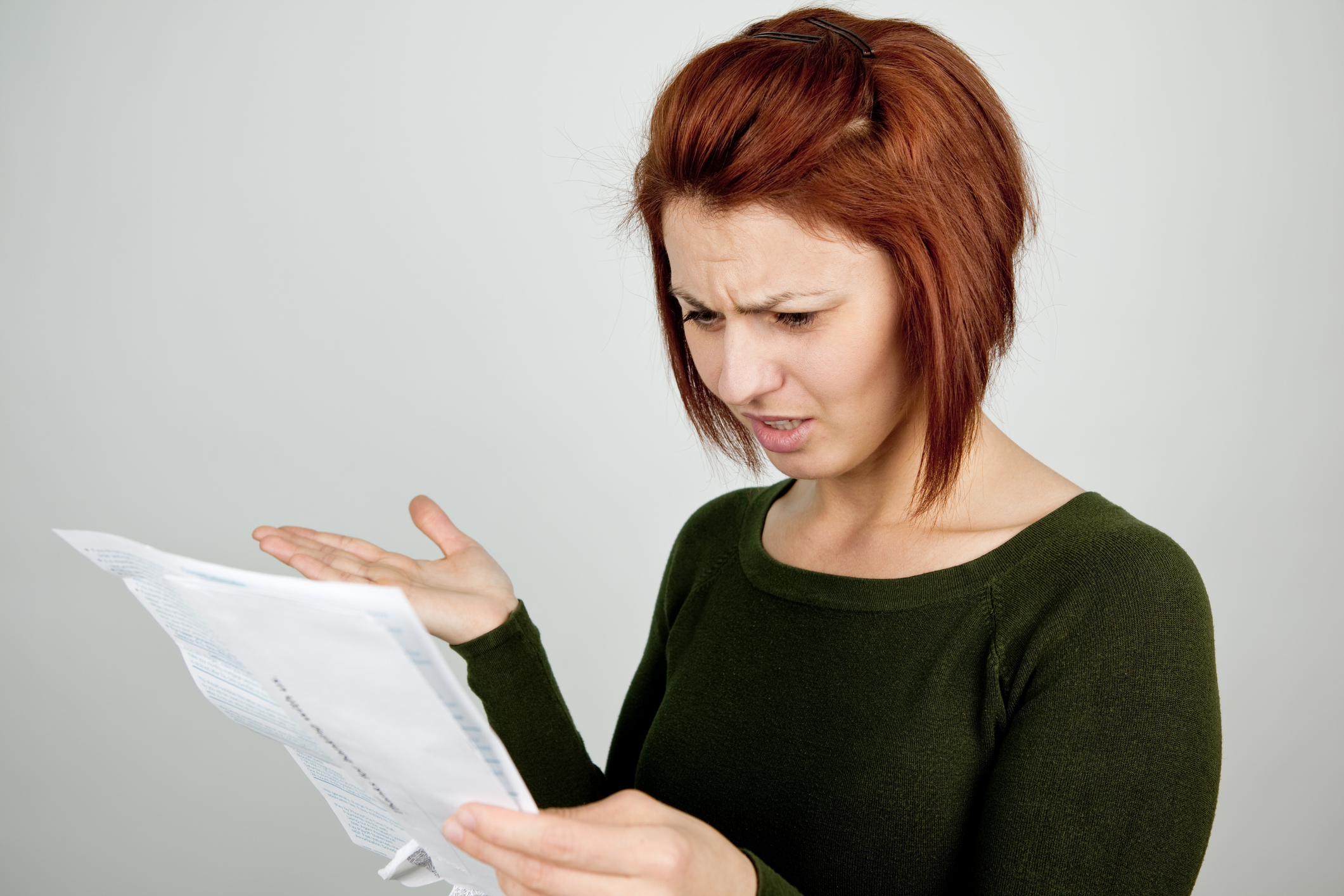 Disbelieved woman looking down at credit card statement