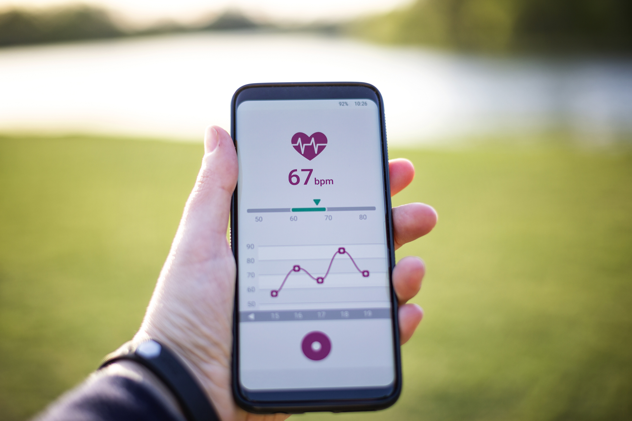 Woman holding smartphone, using fitness app