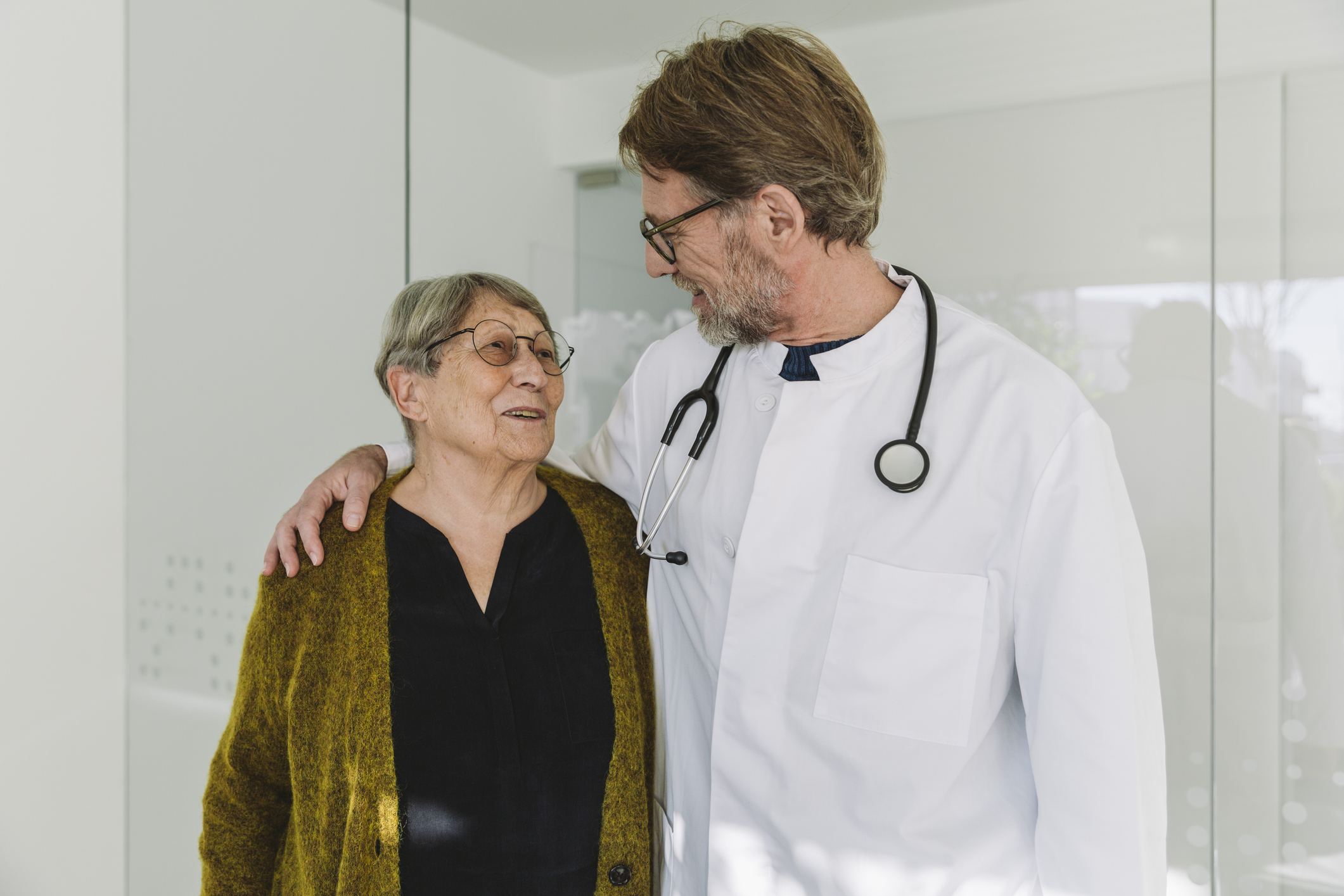 Caring doctor talking to senior patient in medical practice