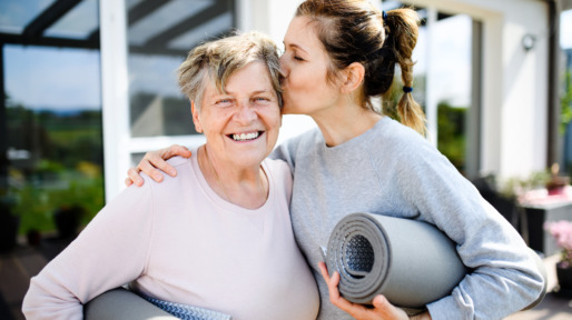 Portrait of woman with senior mother resting after exercise outdoors.