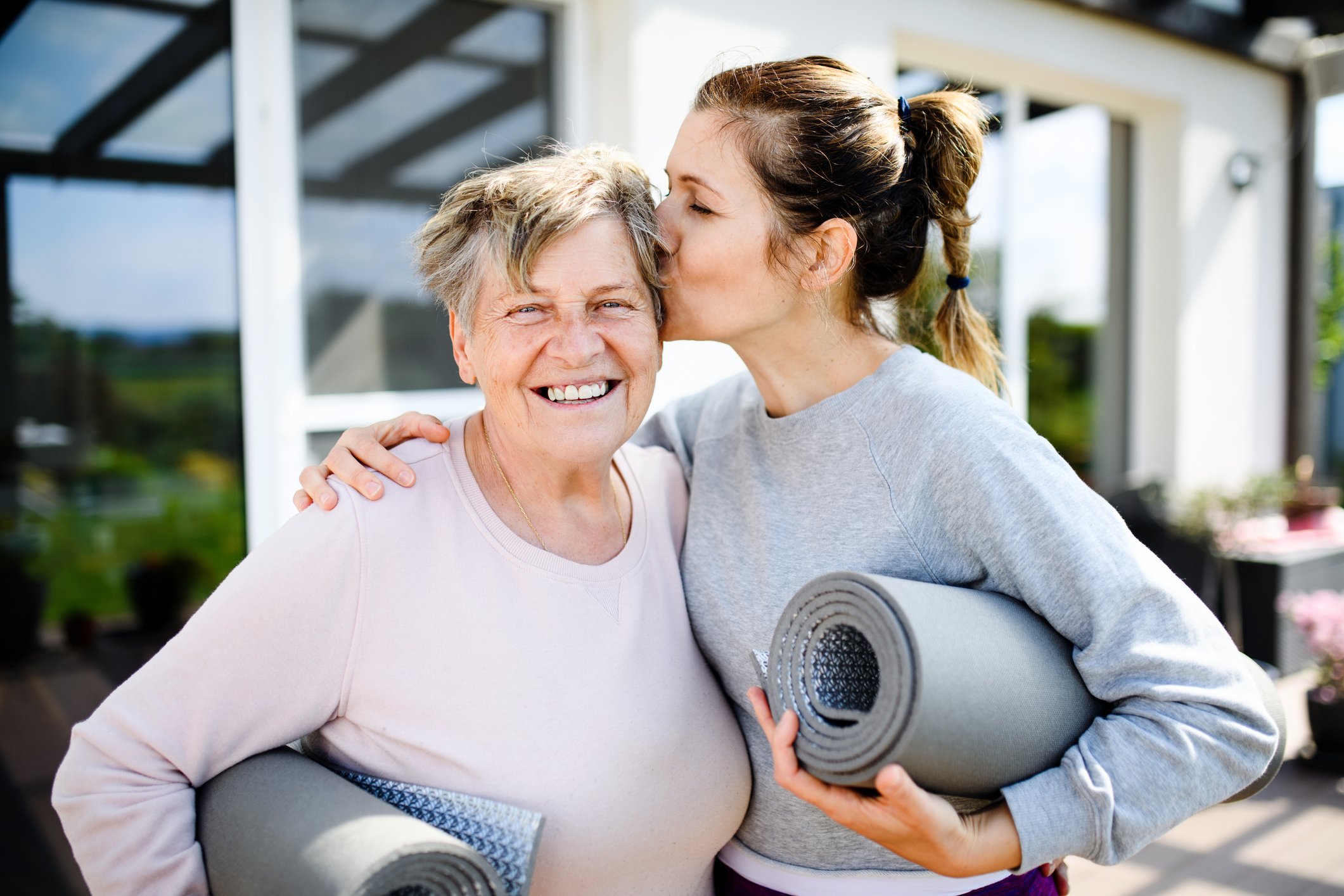 Portrait of woman with senior mother resting after exercise outdoors.
