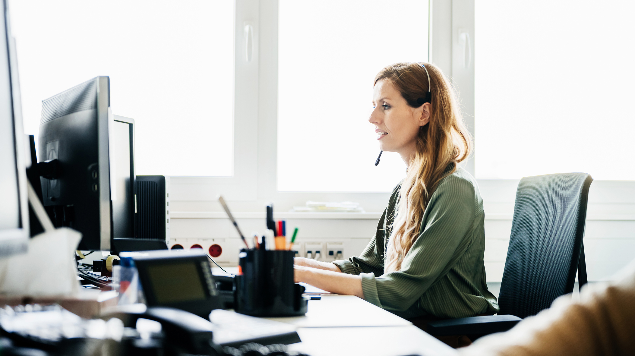 Woman Busy At Work Talking To Customers On The Phone