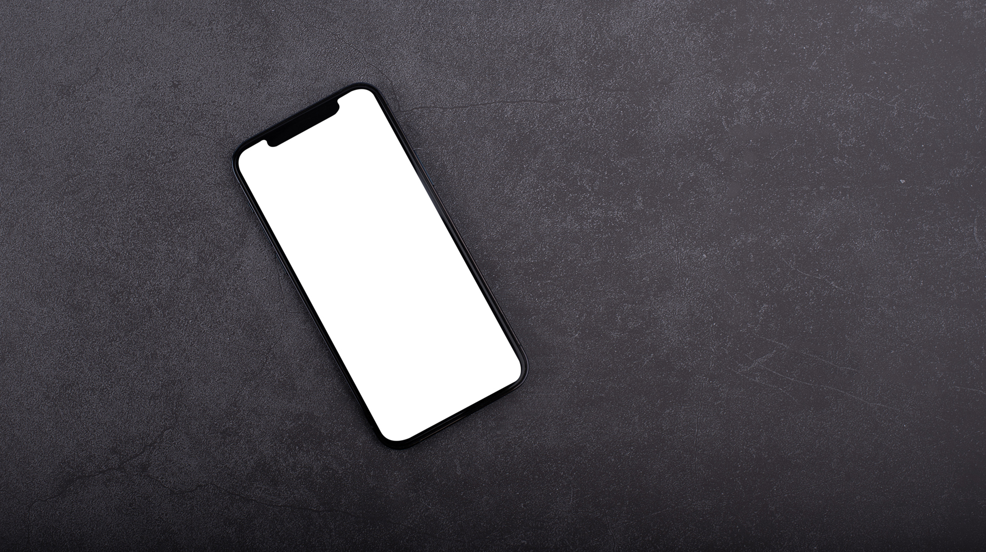Mobile phone with empty screen on black desktop. Top view