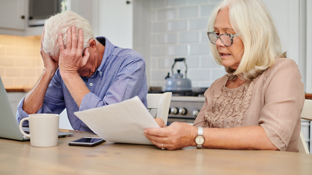 Shot of a senior couple looking unhappy while going through paperwork at home