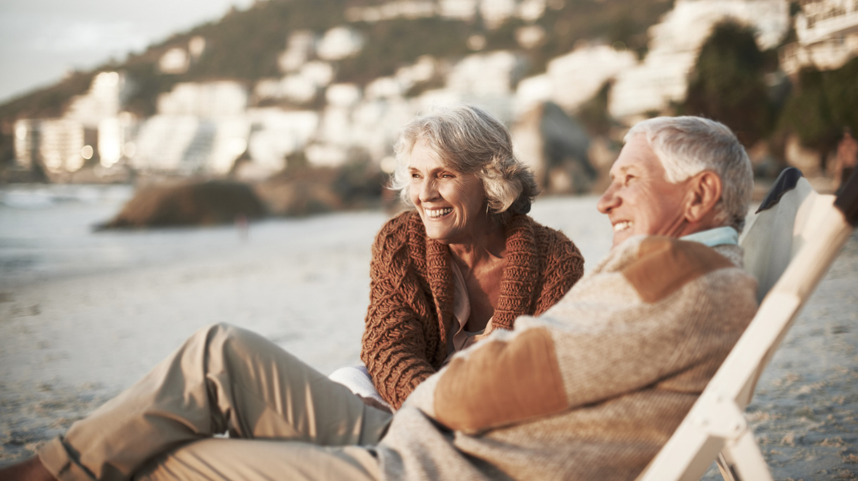 Happy couple relaxing on chairs at beach