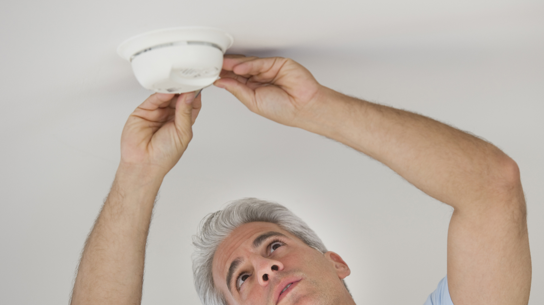 Man testing smoke detector