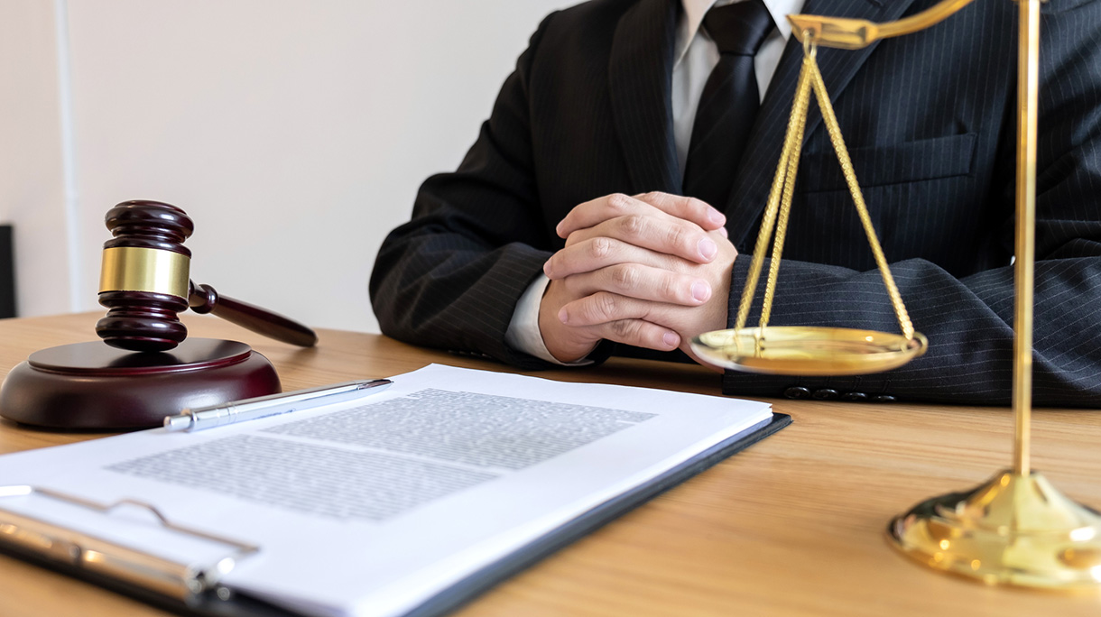 Midsection Of Lawyer With Papers Sitting At Table