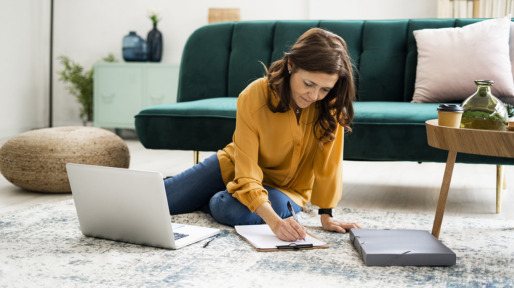 Woman checking bills while sitting on floor at home