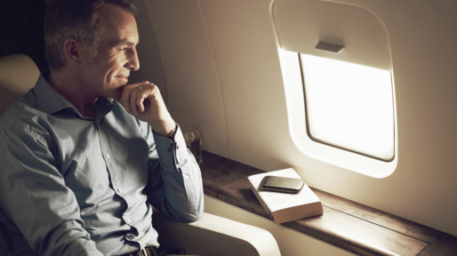 Businessman gazing out of window aboard flight