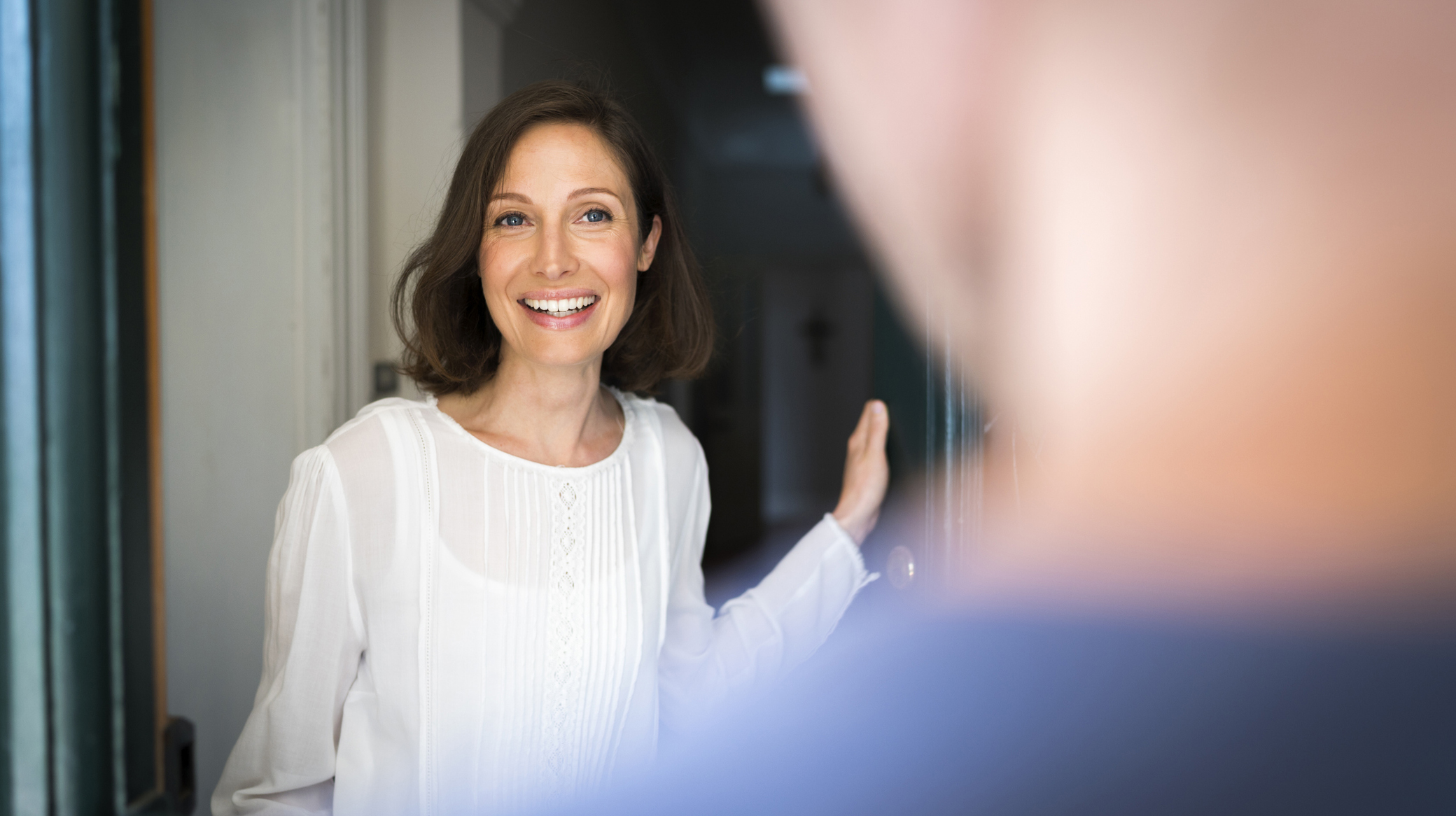 Smiling mid adult woman standing on entrance