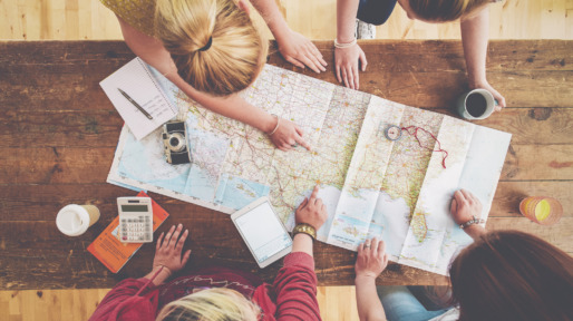Caucasian women planning trip with map on wooden table