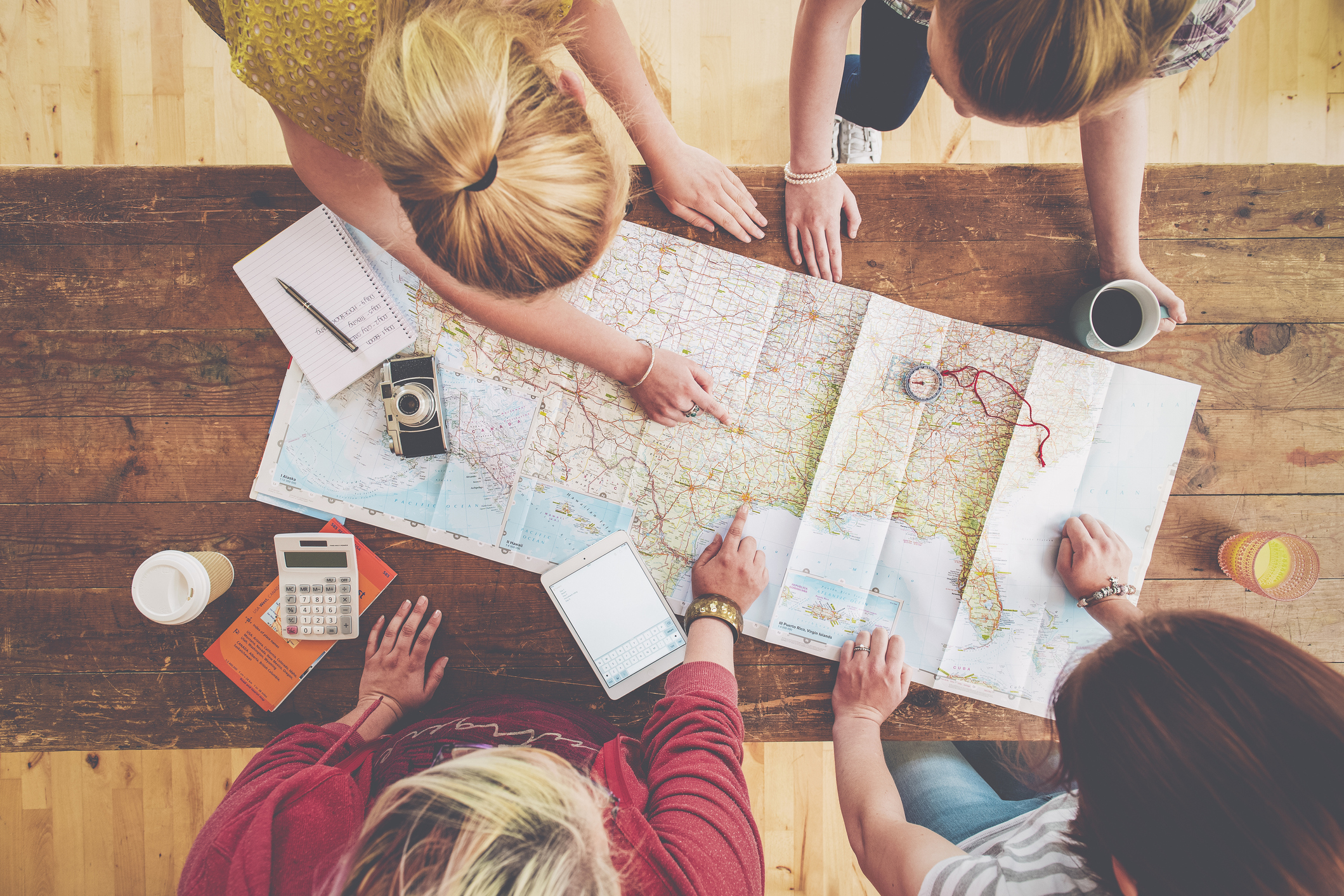 Caucasian women planning trip with map on wooden table