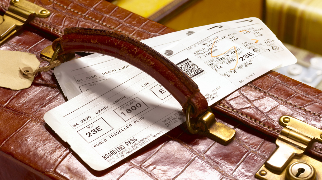 crocodile skin suitcase and boarding pass