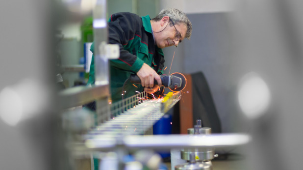 Industrial worker  grinding in manufacturing plant.