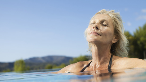 Mature woman relaxing in pool with eyes closed