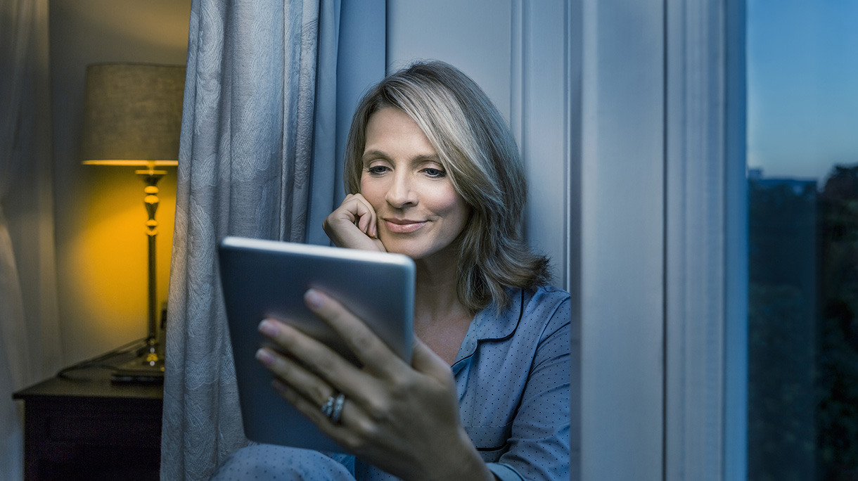 Mature woman using digital tablet at home