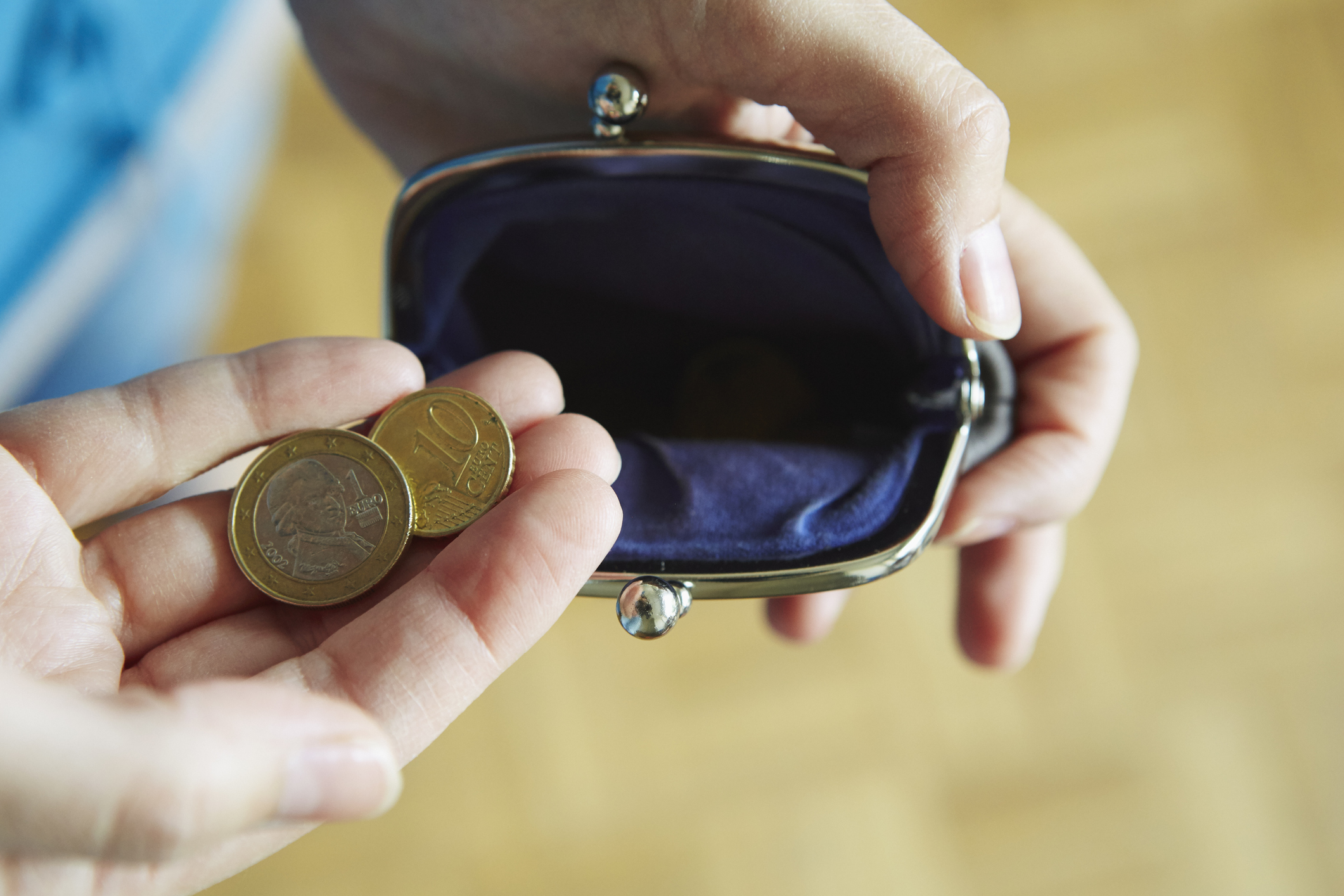 Young woman holding coins from purse, close-up