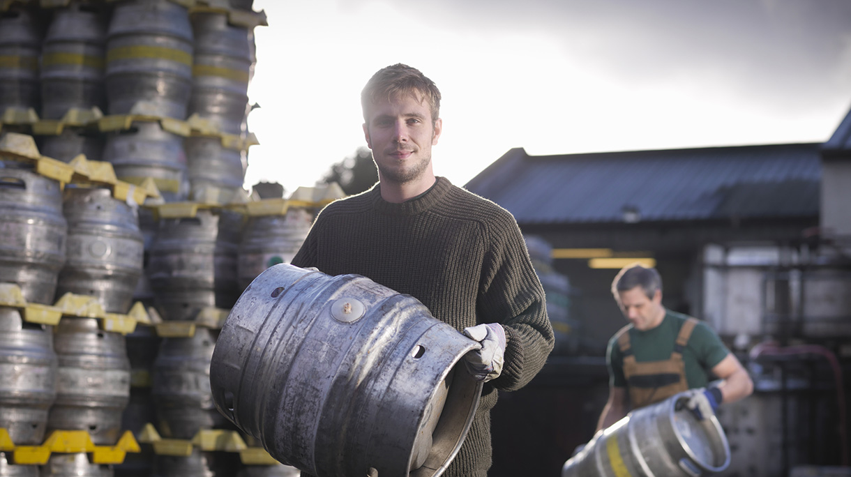 Workers with barrels outside brewery