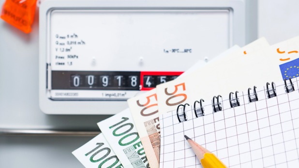 Payment of utility services, concept image. Notebook with Euro bills on the background of a gas meter