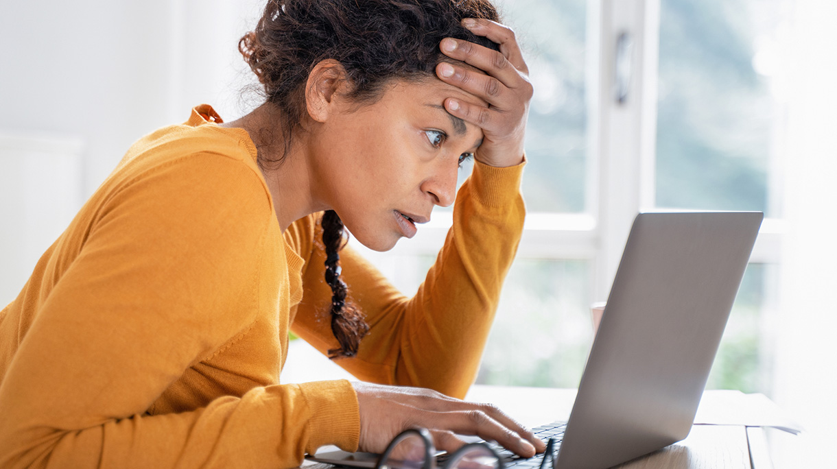 Young woman feeling stressed while looking bank account online