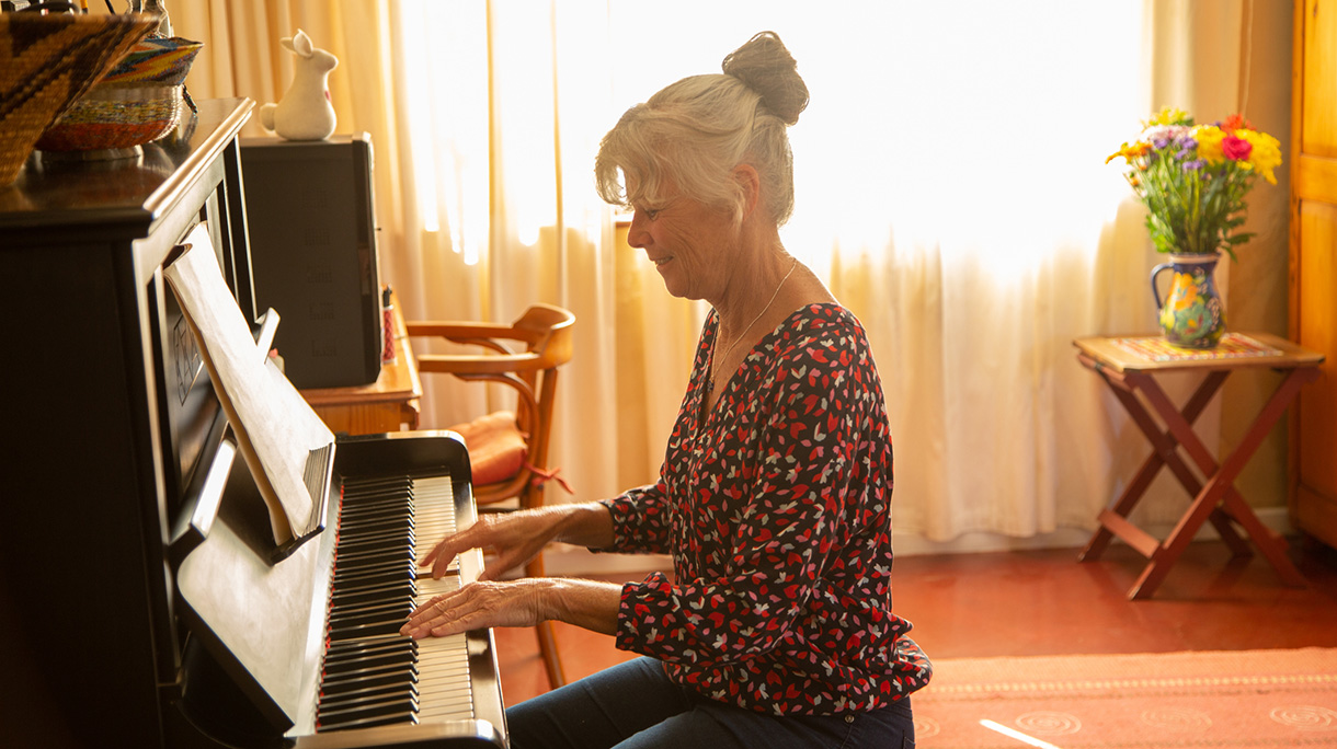 Senior woman playing the piano in her home