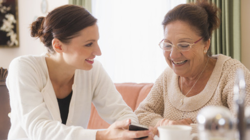 Hispanic woman showing cell phone to grandmother