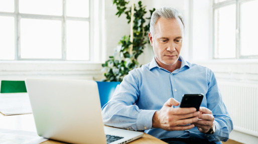 Office Manager Using Smartphone And Laptop